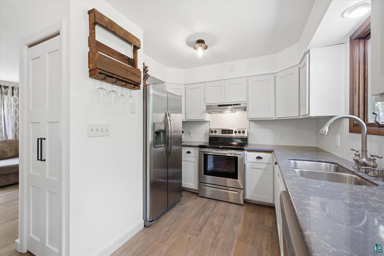 6377 Bergstrom Road Saginaw, MN 55779 - Photo 5 of 20 Well-appointed kitchen featuring light-toned cabinetry, stainless steel appliances, and wood-finish flooring