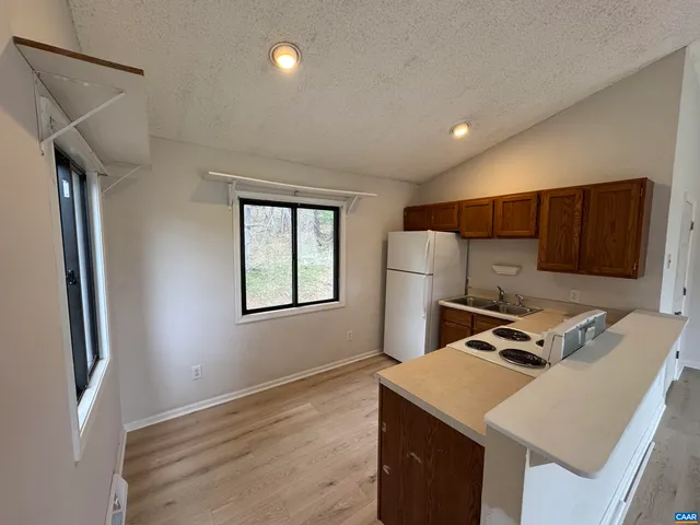 a kitchen with stainless steel appliances kitchen island sink refrigerator and window