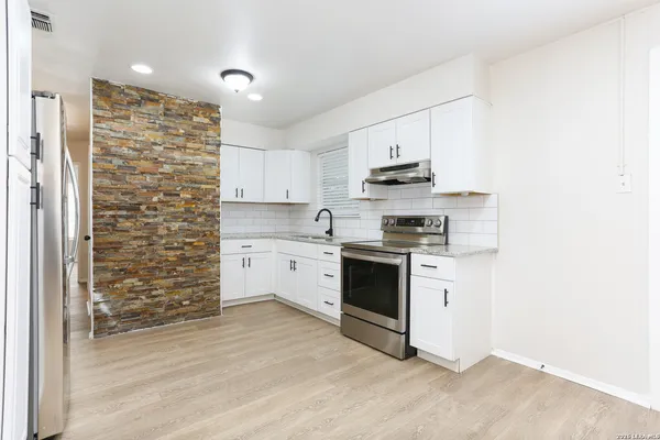 a kitchen with stainless steel appliances a stove a sink and a refrigerator