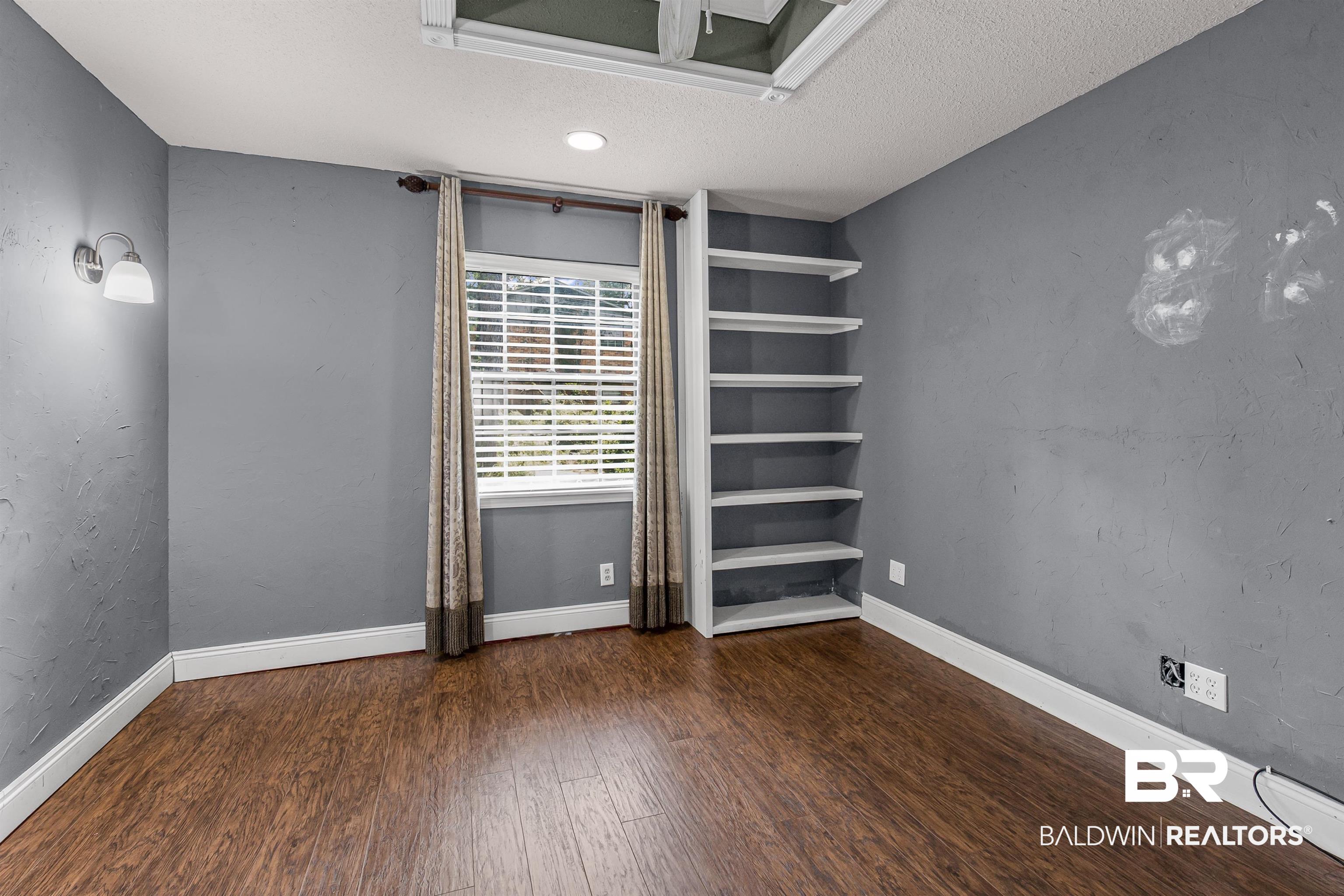 36 Ridgeview Drive Mobile, AL 36611 - Photo 16 of 20 Unfurnished room with a textured wall, dark wood finished floors, and a textured ceiling