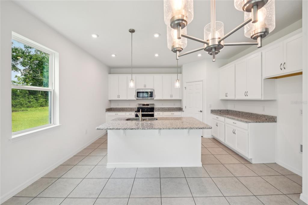 9596 Starling Loop Leesburg, FL 34788 - Photo 15 of 39 a kitchen with a stove a sink and a refrigerator