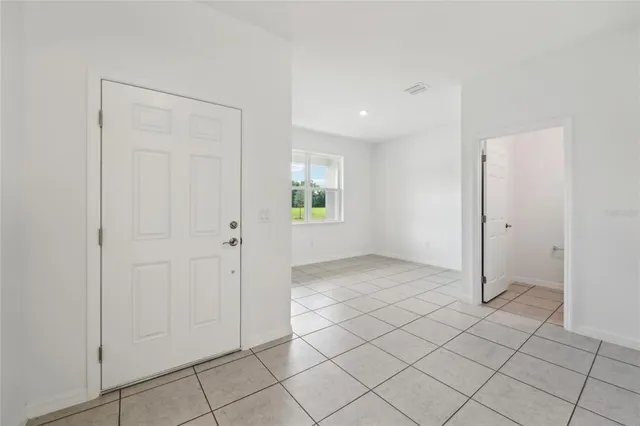 an empty room with kitchen view