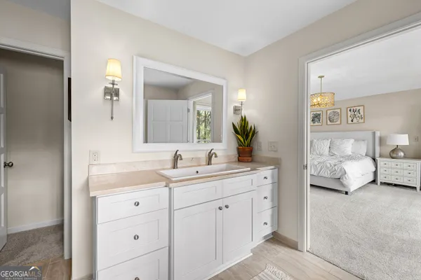 a bedroom with a bed and a dresser next to a window