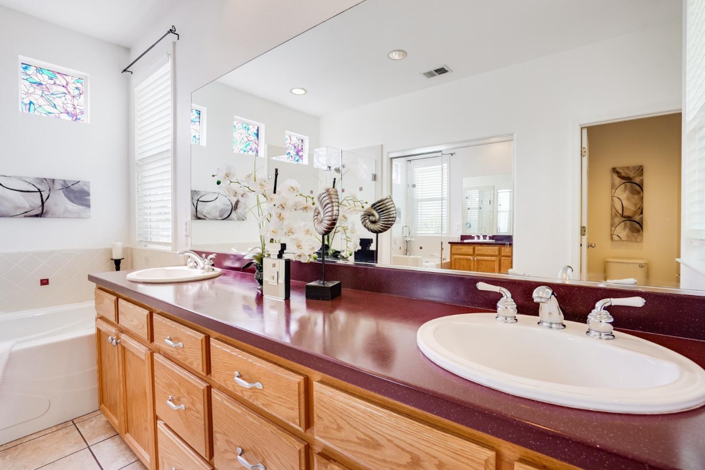 779 Canoas Creek Circle San Jose, CA 95136 - Photo 35 of 58 a bathroom with double vanity sinks a mirror and a shower