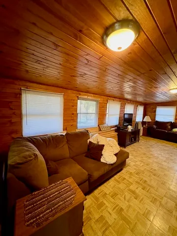 a living room with furniture a flat screen tv and kitchen view