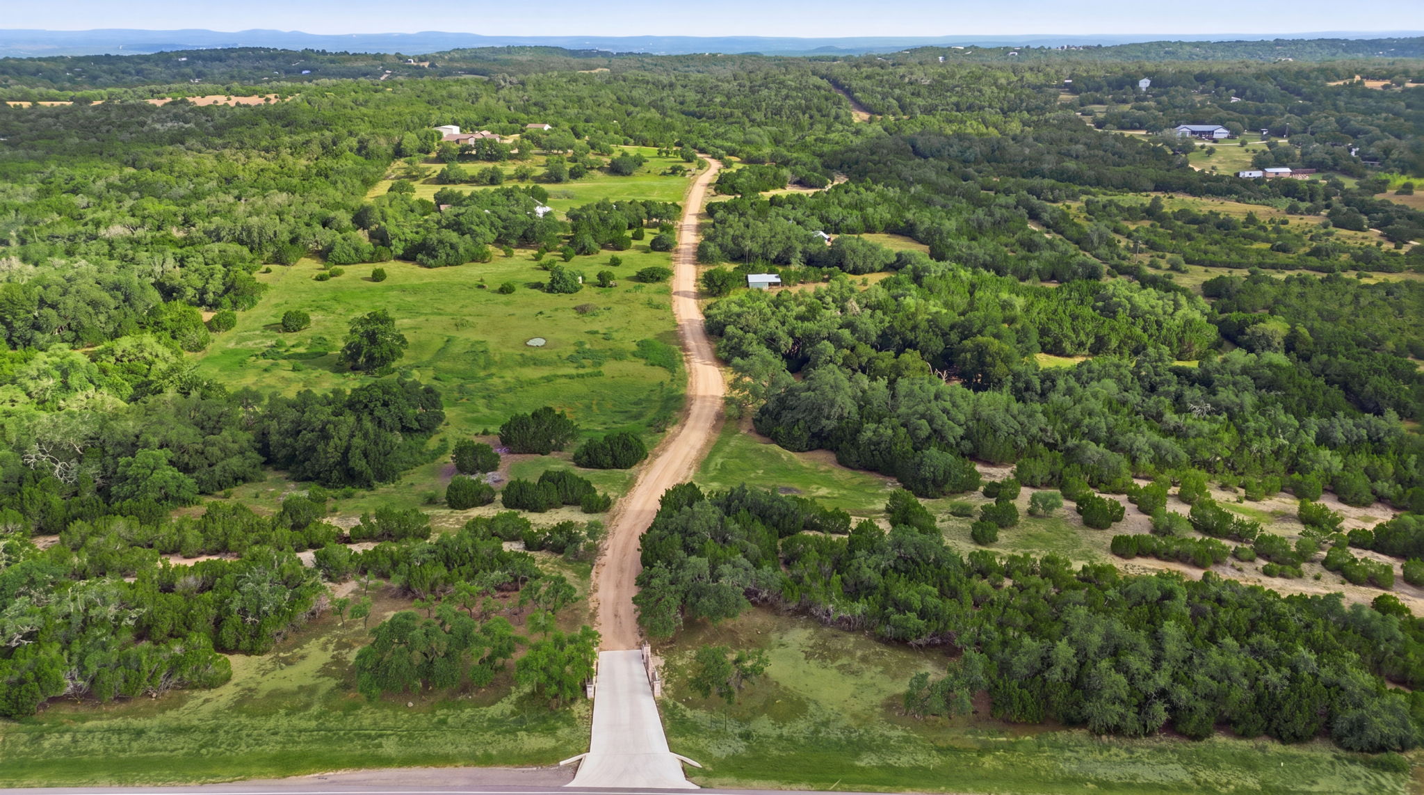 271 Rollin N Ranch Road Blanco, TX 78606 - Photo 3 of 40 A winding path traverses lush, verdant landscapes, hinting at tranquil, secluded acreage.