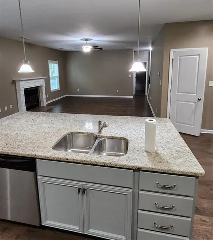 a kitchen with granite countertop a sink and a refrigerator