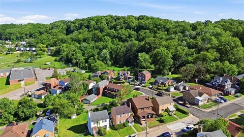 an aerial view of residential houses with outdoor space and street view