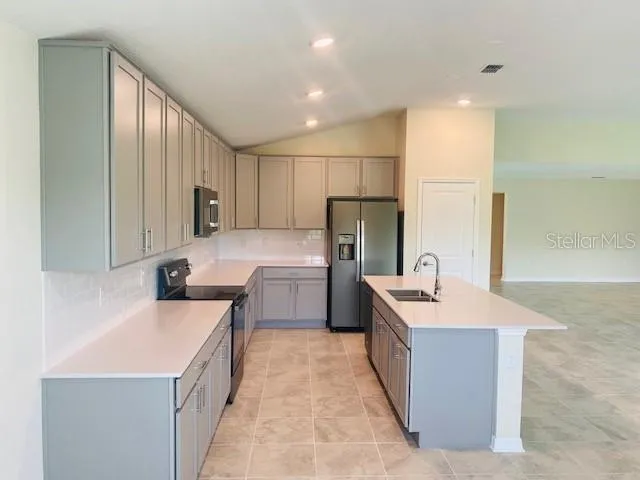 a kitchen with a sink a stove a refrigerator a washer dryer and cabinets