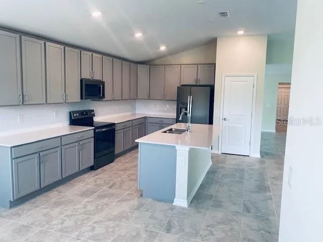 a kitchen with kitchen island a sink stainless steel appliances and cabinets