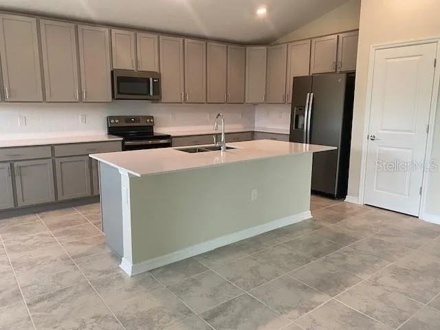 a kitchen with stainless steel appliances a refrigerator a stove a sink a microwave and cabinets