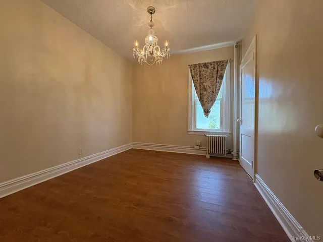 a view of a room with wooden floor and window