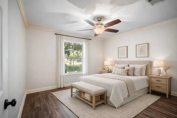 a view of empty room with wooden floor and fan
