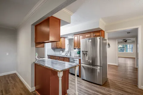 a kitchen with stainless steel appliances a refrigerator and wooden floor