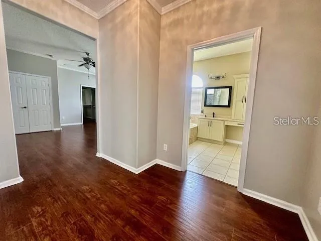an empty room with wooden floor and a bathroom