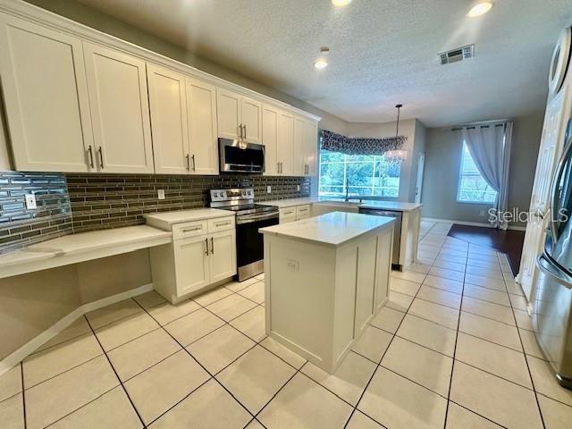806 Winder Oaks Drive Gotha, FL 34734 - Photo 5 of 47 a kitchen with stainless steel appliances granite countertop a stove a sink and a microwave