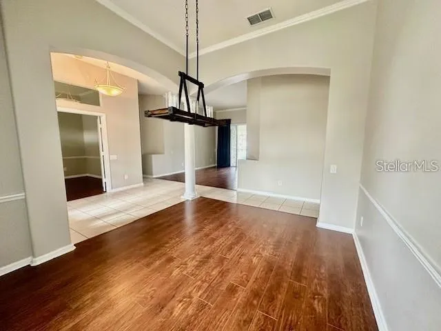 a view of empty room with wooden floor