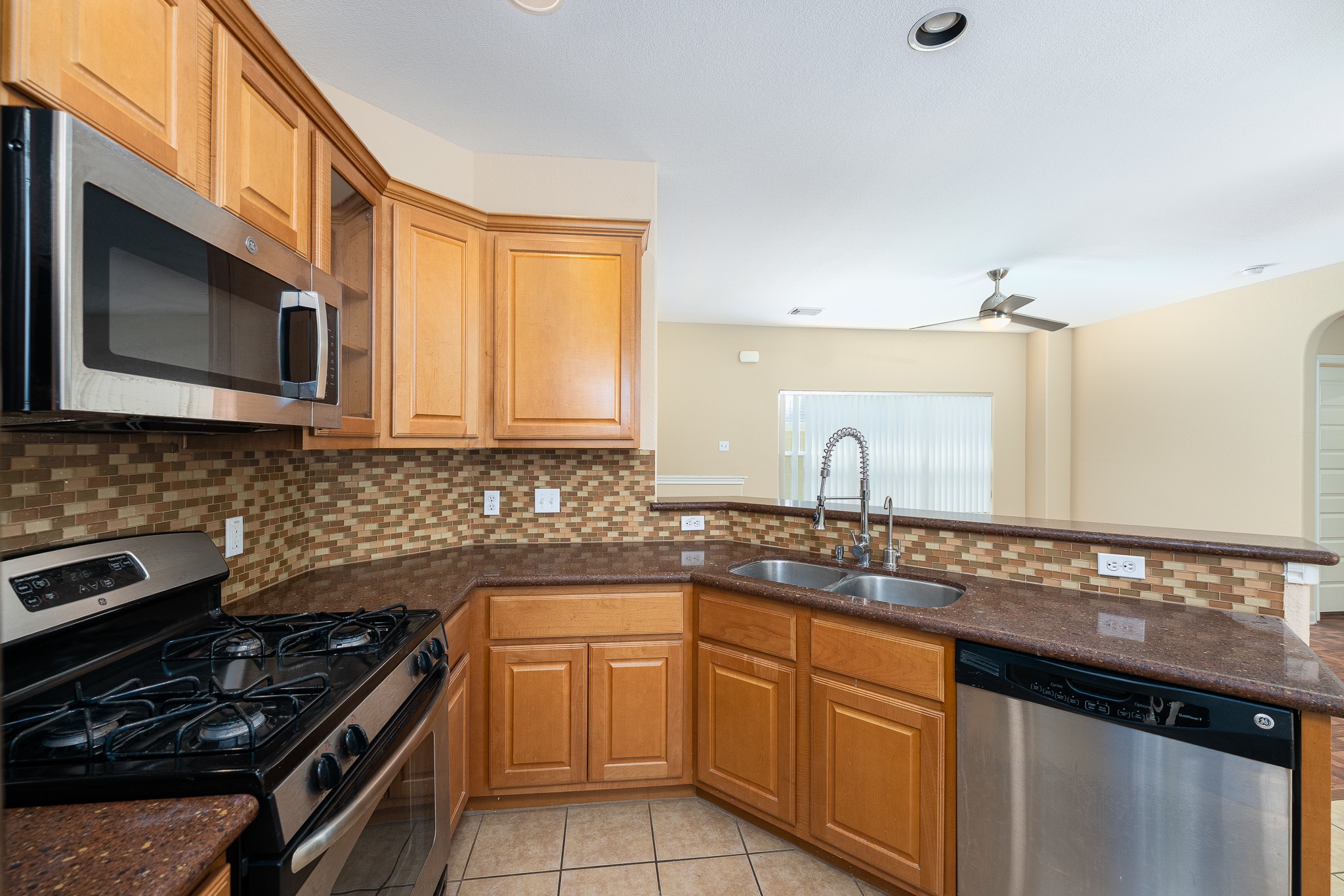 2829 Saville Loop, Unit 17C Austin, TX 78741 - Photo 20 of 28 A well-appointed kitchen features rich wood cabinetry, granite countertops, and modern stainless steel appliances.