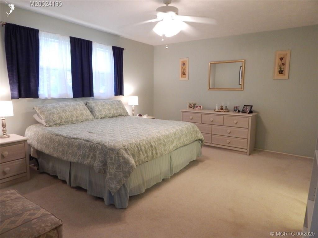 2950 Southeast Ocean Boulevard, Unit 1225 Stuart, FL 34996 - Photo 12 of 39 a bedroom with a bed and a chandelier