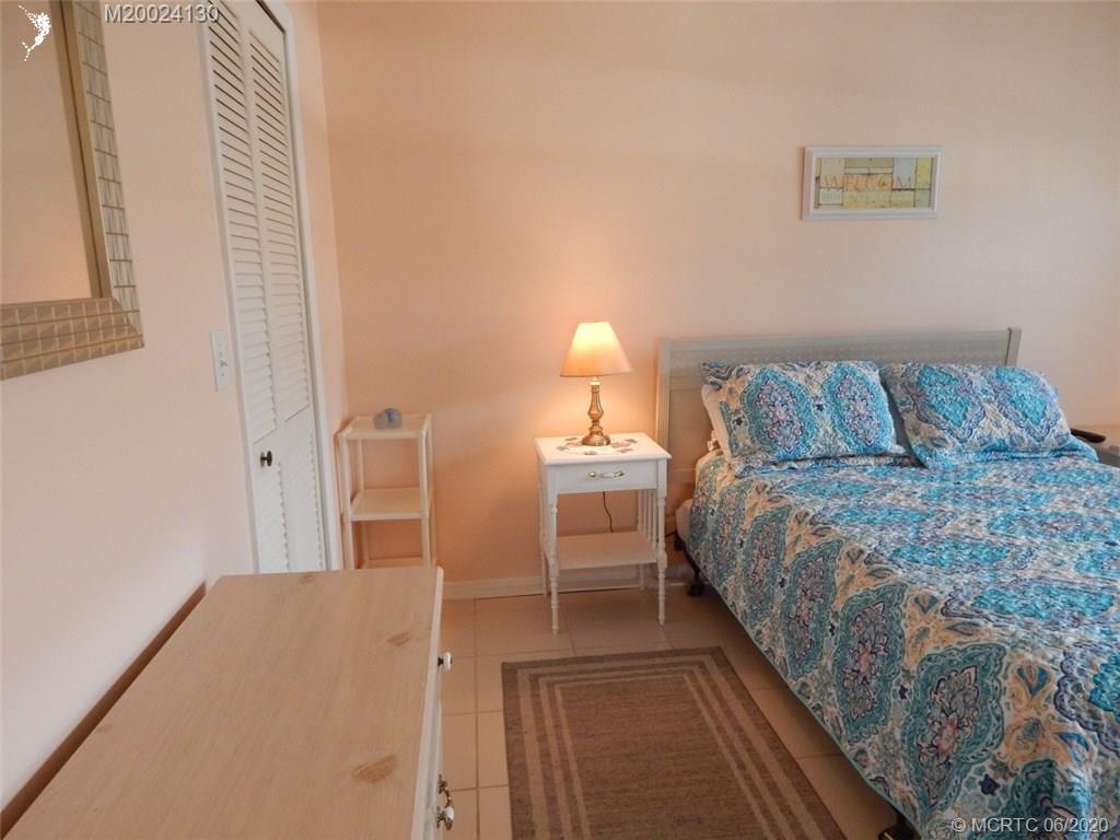 2950 Southeast Ocean Boulevard, Unit 1225 Stuart, FL 34996 - Photo 21 of 39 a bedroom with a bed and a lamp