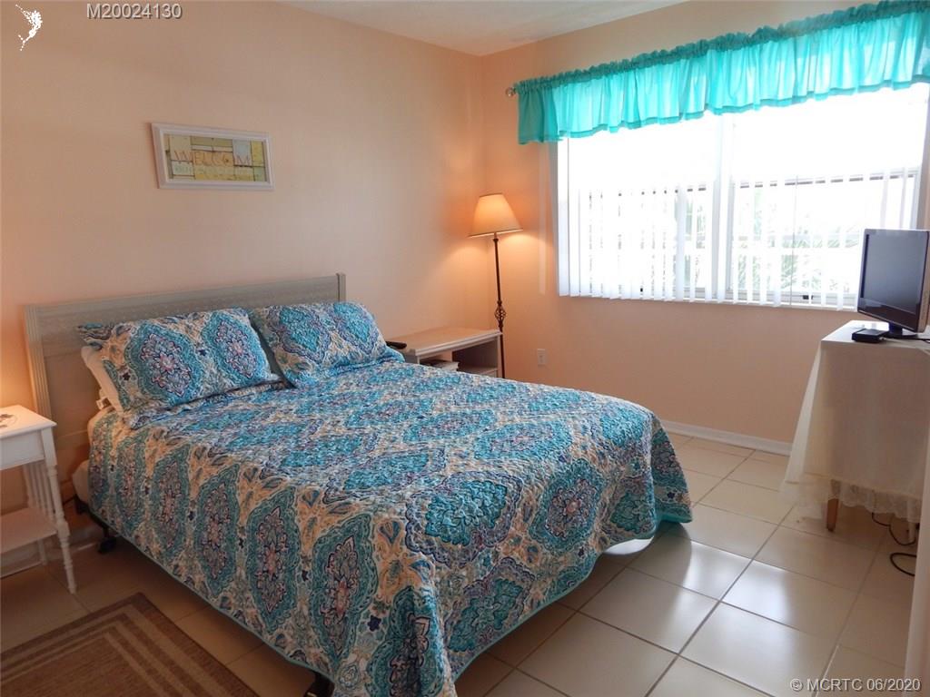 2950 Southeast Ocean Boulevard, Unit 1225 Stuart, FL 34996 - Photo 22 of 39 a bed sitting in a bedroom next to a window