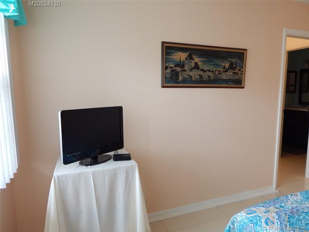 2950 Southeast Ocean Boulevard, Unit 1225 Stuart, FL 34996 - Photo 23 of 39 a living room with furniture and a flat screen tv