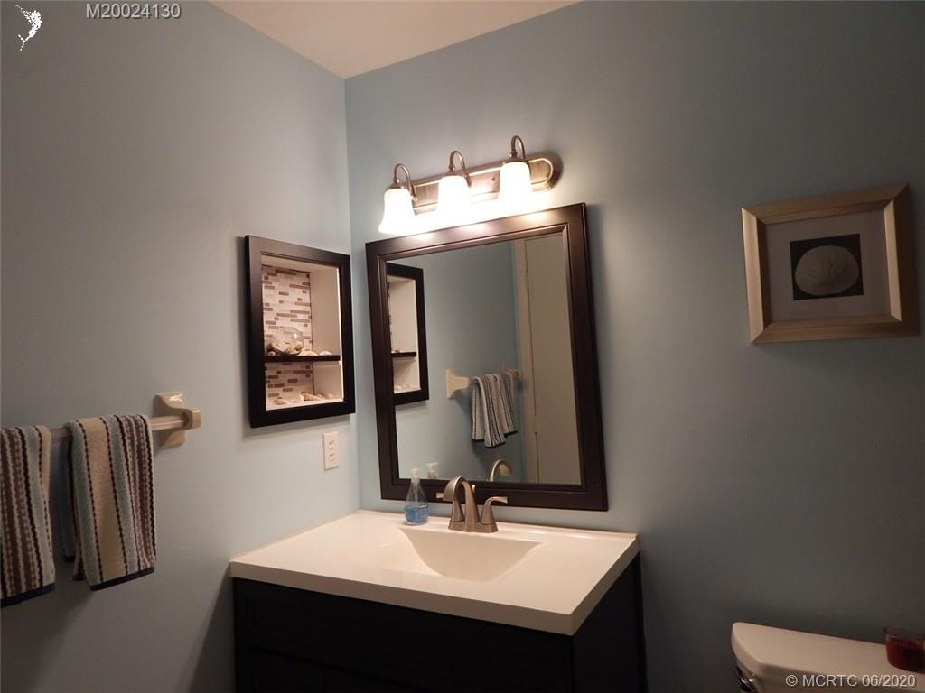 2950 Southeast Ocean Boulevard, Unit 1225 Stuart, FL 34996 - Photo 28 of 39 a bathroom with a sink toilet and mirror