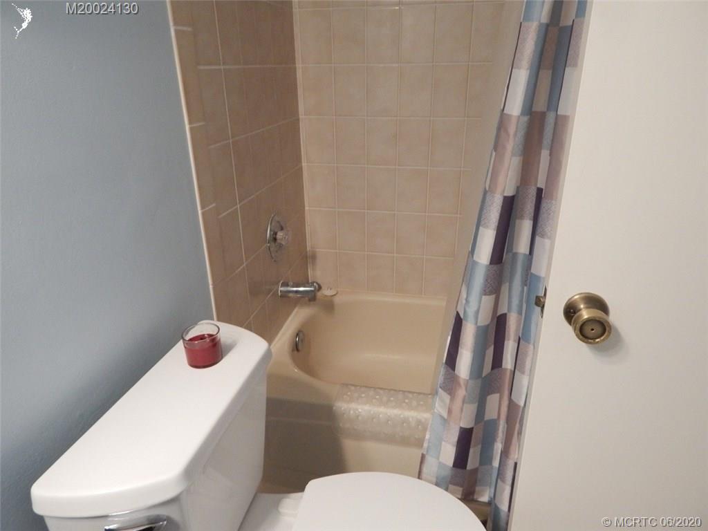 2950 Southeast Ocean Boulevard, Unit 1225 Stuart, FL 34996 - Photo 31 of 39 a white toilet sitting next to a bathroom sink and tub
