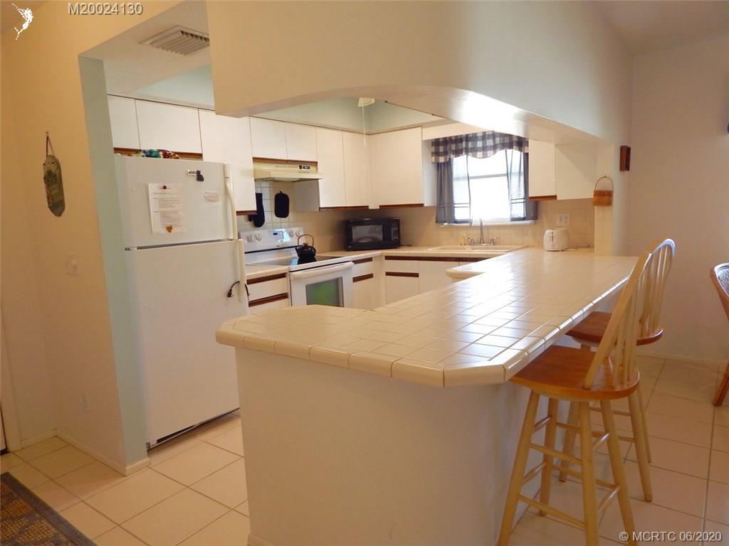 2950 Southeast Ocean Boulevard, Unit 1225 Stuart, FL 34996 - Photo 6 of 39 a kitchen with stainless steel appliances granite countertop a sink a stove a refrigerator a washer and dryer
