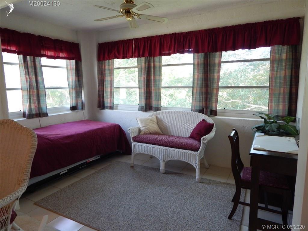 2950 Southeast Ocean Boulevard, Unit 1225 Stuart, FL 34996 - Photo 10 of 39 a bedroom with a bed and a chair