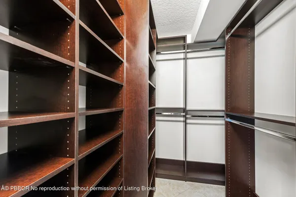 a view of a house with a yard and palm trees