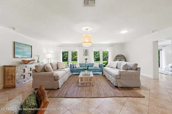 a living room with furniture kitchen view and a wooden floor