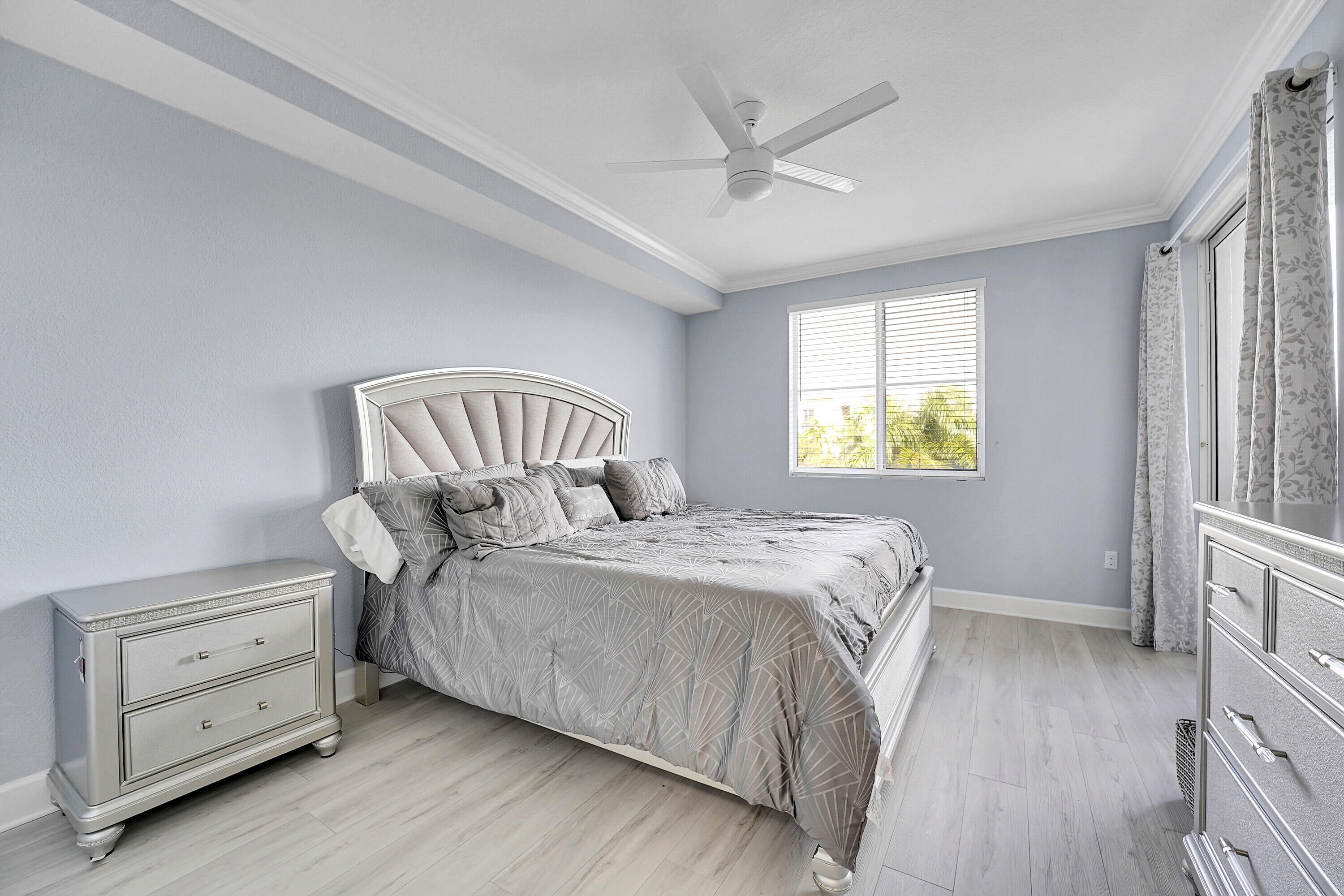 1690 Renaissance Commons Boulevard, Unit 1401 Boynton Beach, FL 33426 - Photo 15 of 43 a bedroom with a bed a dresser and a window