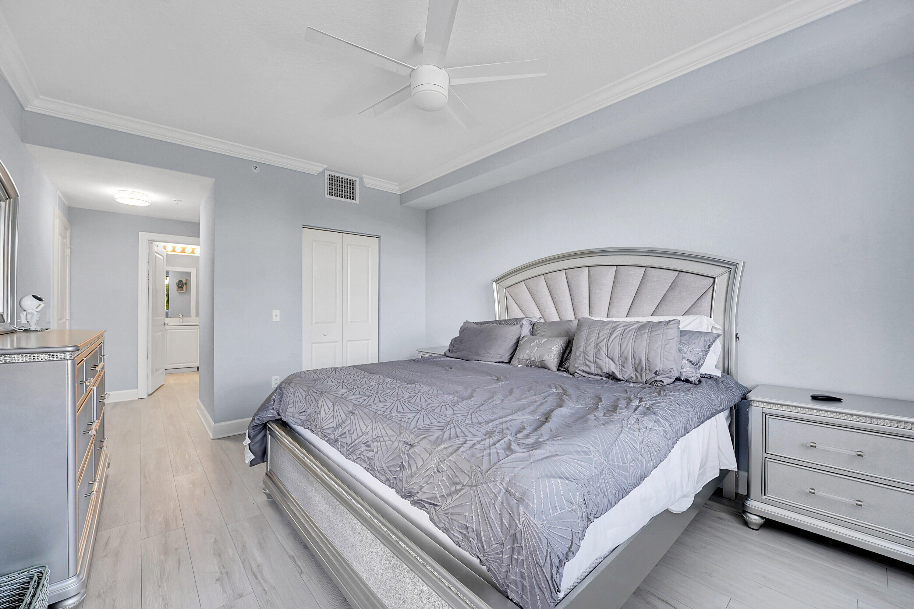 1690 Renaissance Commons Boulevard, Unit 1401 Boynton Beach, FL 33426 - Photo 16 of 43 a bedroom with a bed and a chandelier