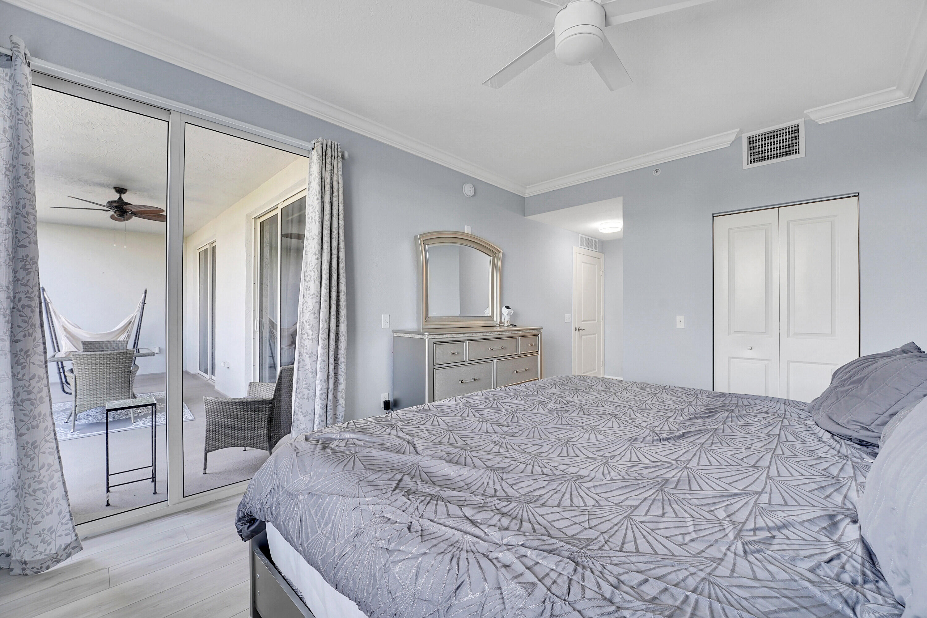 1690 Renaissance Commons Boulevard, Unit 1401 Boynton Beach, FL 33426 - Photo 17 of 43 a bedroom with a large bed and a chandelier