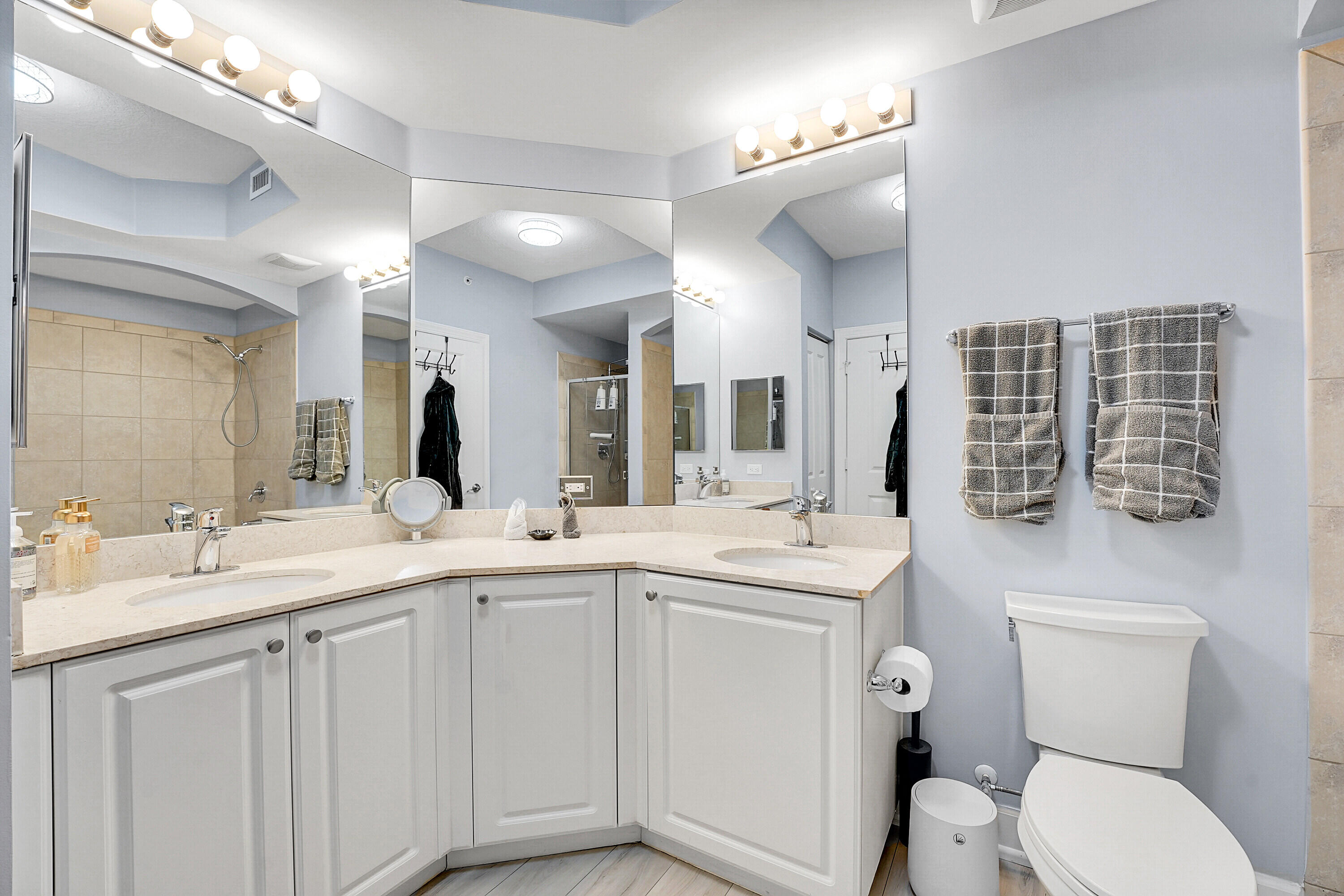 1690 Renaissance Commons Boulevard, Unit 1401 Boynton Beach, FL 33426 - Photo 20 of 43 a spacious bathroom with a double vanity sink toilet and a mirror
