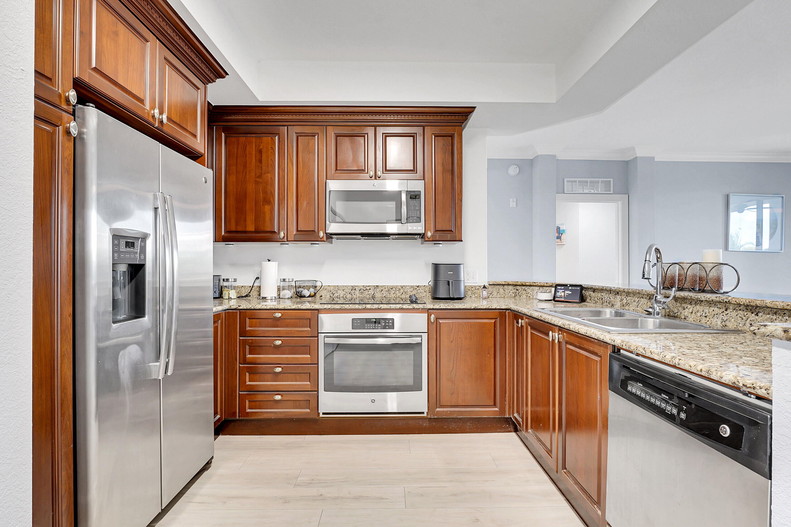 1690 Renaissance Commons Boulevard, Unit 1401 Boynton Beach, FL 33426 - Photo 5 of 43 a kitchen with stainless steel appliances granite countertop a stove and a refrigerator