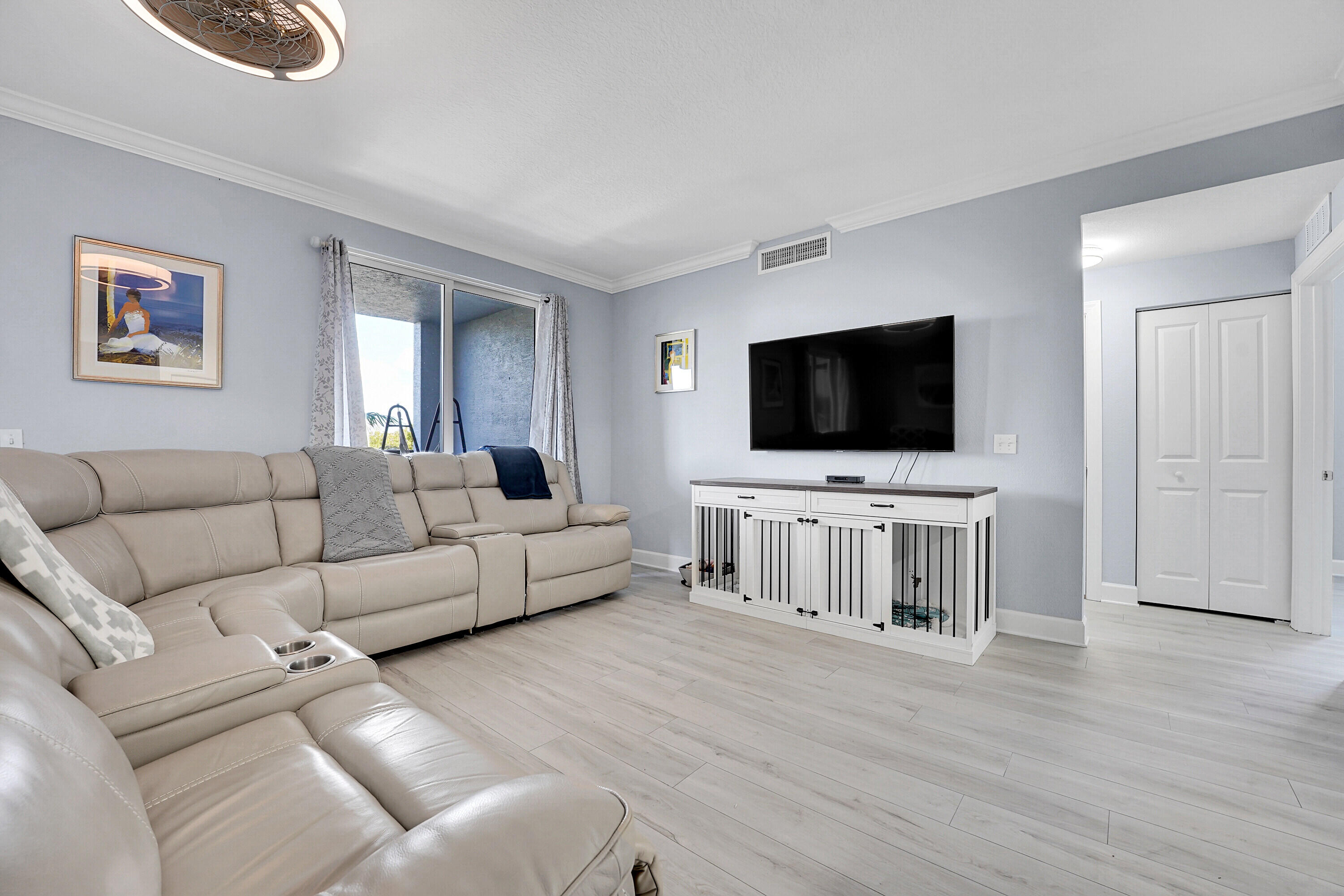 1690 Renaissance Commons Boulevard, Unit 1401 Boynton Beach, FL 33426 - Photo 8 of 43 a living room with furniture and a flat screen tv