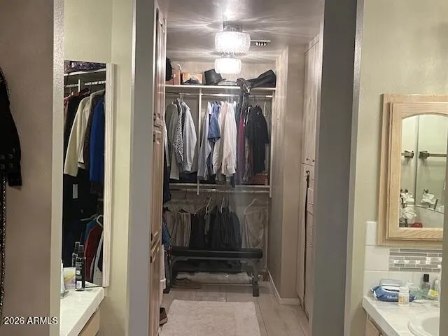 a view of walk in closet with clothes and shoes