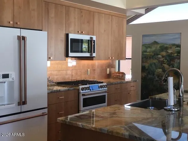 a kitchen with granite countertop a stove and a refrigerator
