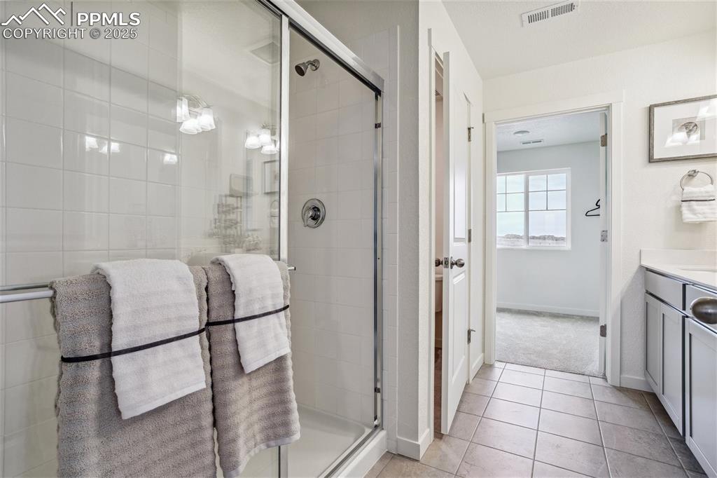 6146 Alpine Rdg Drive Colorado Springs, CO 80925 - Photo 17 of 22 a bathroom with a glass shower door and a sink