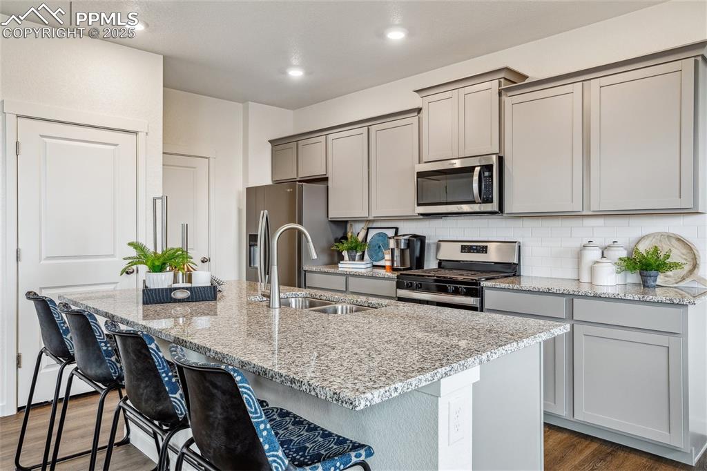 6146 Alpine Rdg Drive Colorado Springs, CO 80925 - Photo 8 of 22 a kitchen with stainless steel appliances granite countertop a stove top oven a sink a refrigerator white cabinets and a refrigerator