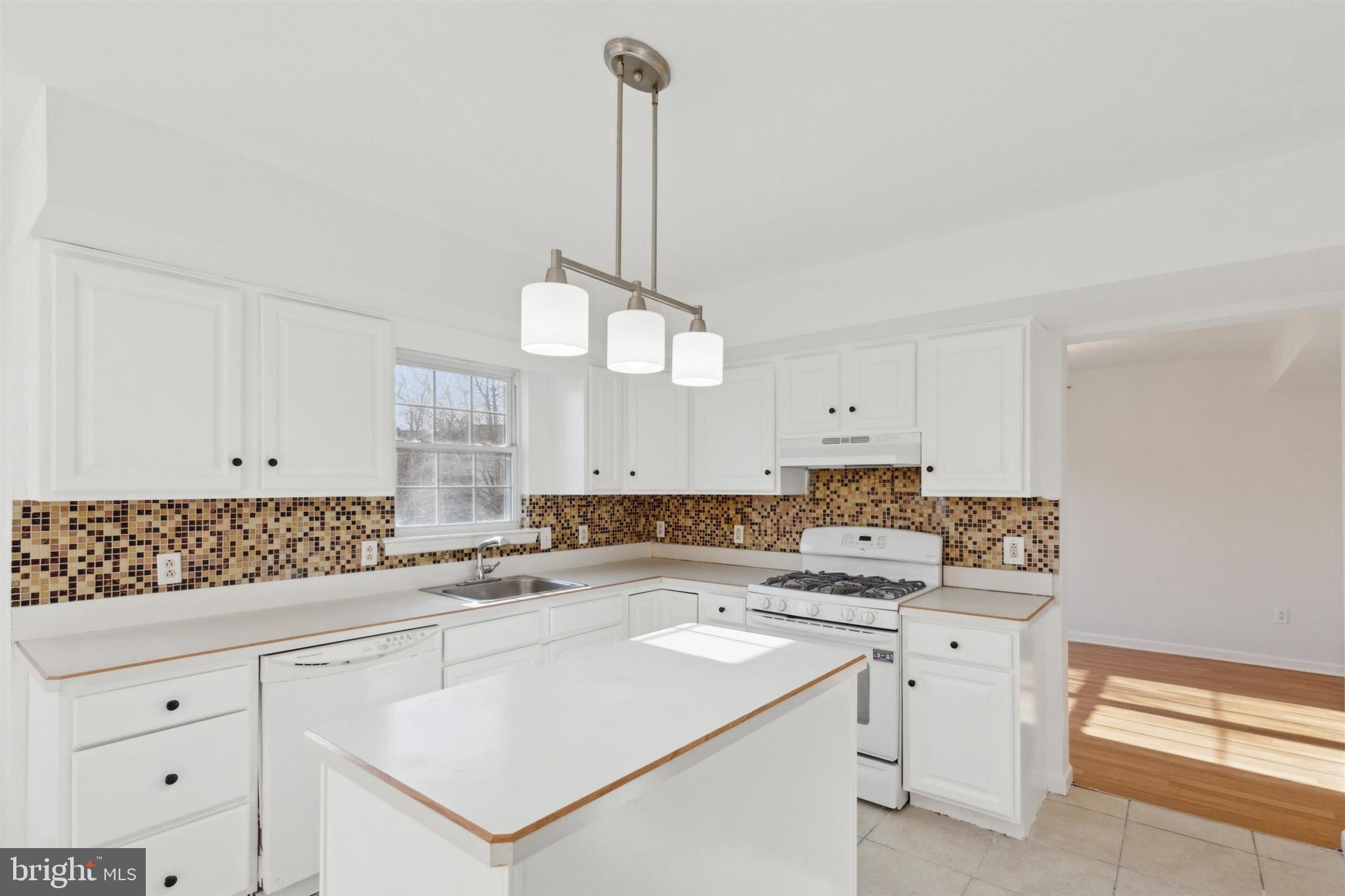 4420 Kelly Lane Reading, PA 19606 - Photo 8 of 25 a kitchen with a sink dishwasher and white cabinets with wooden floor