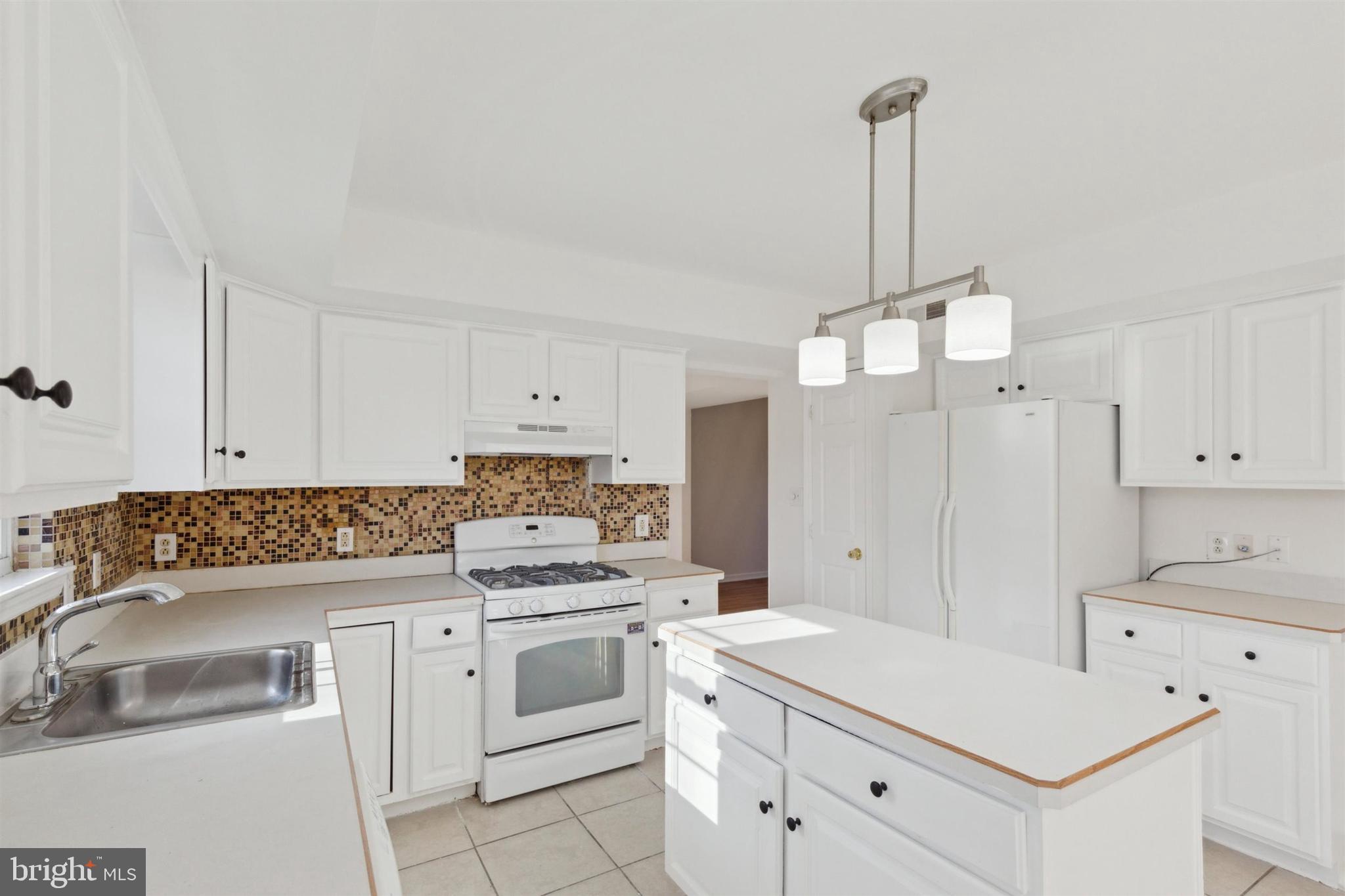 4420 Kelly Lane Reading, PA 19606 - Photo 9 of 25 a kitchen with a stove a sink and a refrigerator