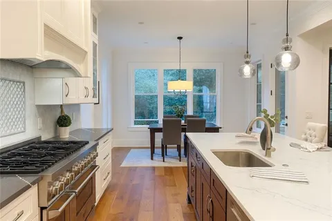 a kitchen that has a sink a stove and a wooden floor