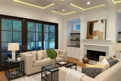 a living room with furniture fireplace and a large window