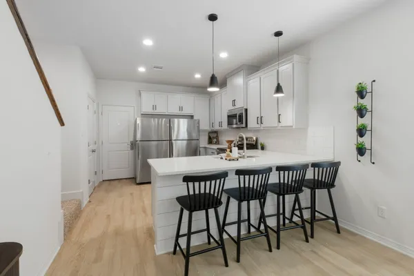 a kitchen with a sink a stove and chairs
