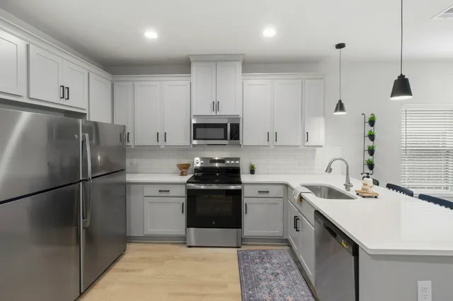 a kitchen with a sink appliances and cabinets