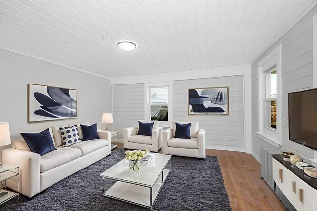 a living room with furniture a rug and a flat screen tv
