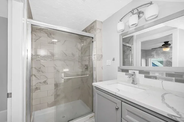 a bathroom with a shower sink and mirror
